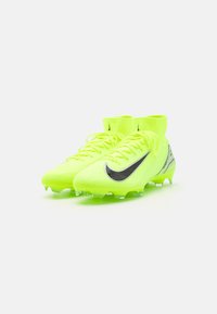 Neoonkollased jalgpalliketsid musta Nike sookusega, tekstureeritud ülemine osa, pahkluu tugi ja läbipaistvad nurgad, et tagada haarduvus väljakul.
