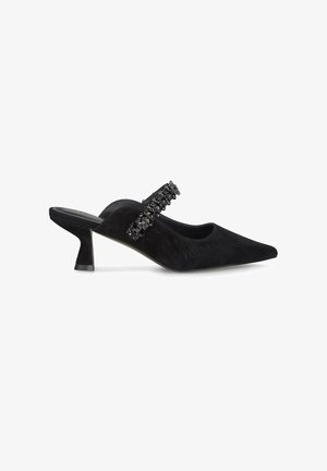 Chaussure slingback en suede noir avec un bout pointu et un petit talon évasé. Dotée d'une sangle décorative ornée d'éléments noirs sur le cou-de-pied.