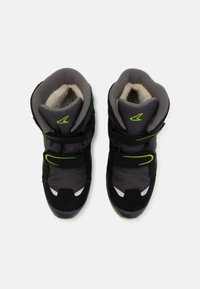 Black sports shoes with gray accents, featuring green detailing, Velcro straps, and a textured surface. Lined with soft material.