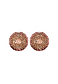 Deux compacts de bronzer circulaires étiquetés "Lever de soleil au paradis", avec des couvercles texturés présentant des tourbillons, dans des tons beige chaud et des fermetures transparentes.