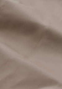 Tessuto beige chiaro con una superficie liscia, leggermente lucida e un sottile elasticità. Nessun motivo o design visibile.