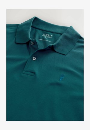 Tirkizna polo majica od teksturiranog materijala sa ovratnikom, dvobotonim kopčanjem i izvezenim logotipom jelena. Dizajn regularnog kroja.