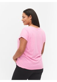 Camiseta de manga corta rosa de algodón, con un ajuste relajado y un escote redondeado. Tejido texturizado, de color sólido con mangas enrolladas.