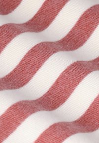 Baumwollstoff mit abwechselnd gekrümmten Streifen in sanftem Rosa und Weiß. Die Textur ist leicht flauschig, was das visuelle Interesse verstärkt.