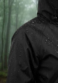 Giacca nera impermeabile con superficie textured. Presenta gocce d'acqua, cappuccio regolabile e elementi di design senza cuciture per la protezione dalle intemperie.