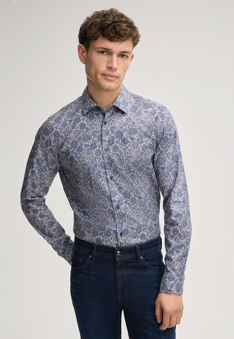 Heren overhemd met lange mouwen in een blauw-wit bloemenpatroon, met een knoopsluiting bij de kraag, in een reguliere maat, gecombineerd met donkere jeans. Katoenen stofstructuur.
