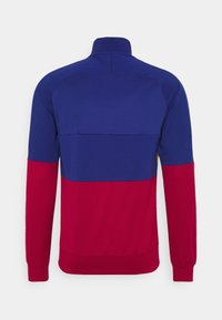 Röd och blå färgblockerad zip-up jacka, långa ärmar, hög krage, slätt tyg, med en horisontell delande söm över ryggen.