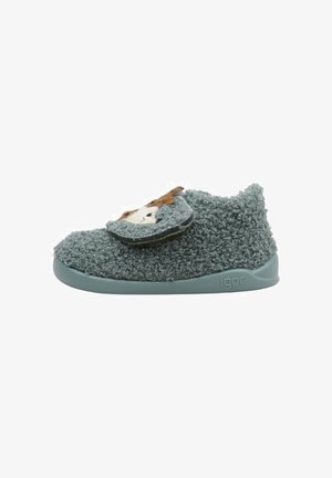 Chaussure d'enfant verte en peluche avec une bride Velcro, présentant un détail de visage d'animal en tissu sur le devant. Texture douce et forme arrondie.
