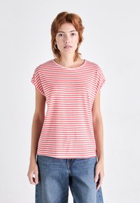 Stripet t-skjorte med horisontale korall- og hvite striper, rund hals og korte ermer, sammen med avslappede blå denim-bukser.
