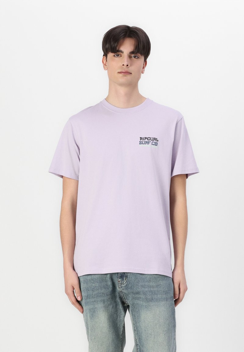 Heledane lilla puuvillane T-särk lühikeste varrukatega. Vasaku rinnaosal on väike must ja roheline "Rip Curl Surf Co" logo.