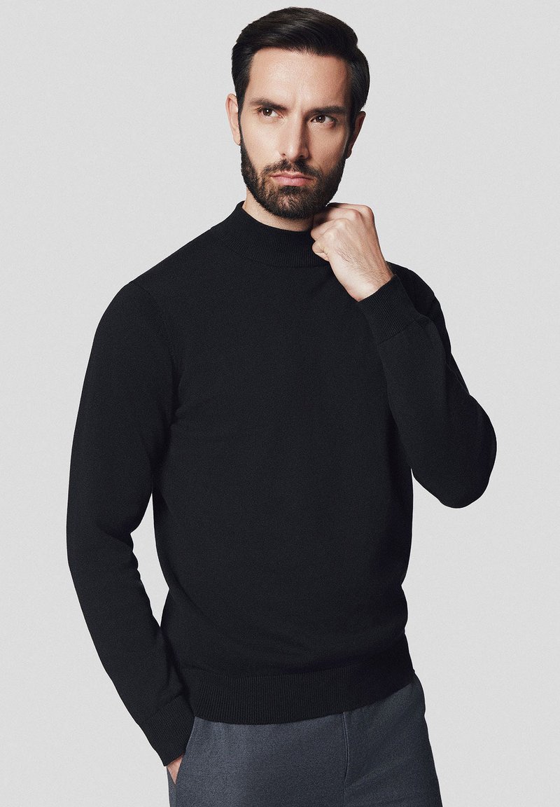 Czarny sweter dzianinowy z wysokim, prążkowanym kołnierzem i długimi rękawami. Gładka faktura, dopasowany krój oraz prążkowane mankiety i dół.