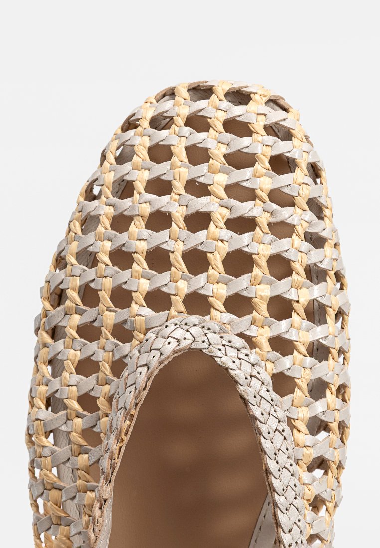 Chaussure ouverte tissée avec un design tressé en gris clair et beige. La tige présente un motif texturé avec un avant arrondi.