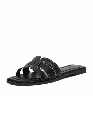 Sandalia slide de cuero negro con tiras recortadas y costuras blancas, suela plana y diseño de punta cuadrada.