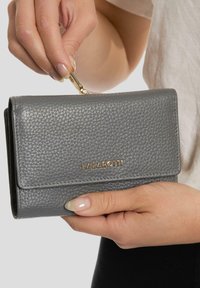 Billetera de cuero gris con una superficie texturizada, herrajes dorados y el nombre de la marca "LAZAROTTI" estampado en la parte frontal.