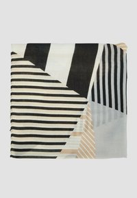 Foulard en soie présentant des motifs géométriques en noir, blanc et beige. Le design inclut des largeurs de rayures variées et des angles vifs, avec une texture douce.