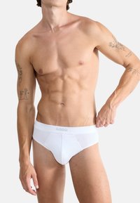 Witte katoenen slips met een gladde textuur en een SLOGGI-logo op de tailleband. Het ontwerp heeft een klassieke snit en naadloze zijkanten.