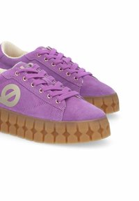 Purple suede sneakers feature a thick, patterned gum sole and flat laces with metallic eyelets. A logo is prominently displayed on the side.