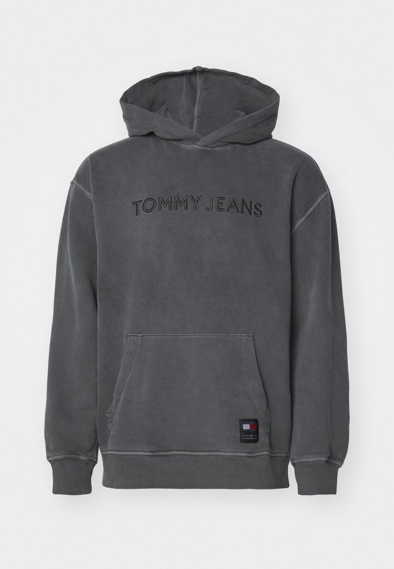 Sudadera con capucha gris hecha de un material suave, con un bolsillo tipo canguro, detalles cosidos y "TOMMY JEANS" bordado en hilo oscuro en la parte delantera.