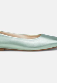 Ballerines vert menthe avec une texture lisse et brillante, dotées d'un bout pointu et d'une semelle basse marron. Design simple et minimaliste.