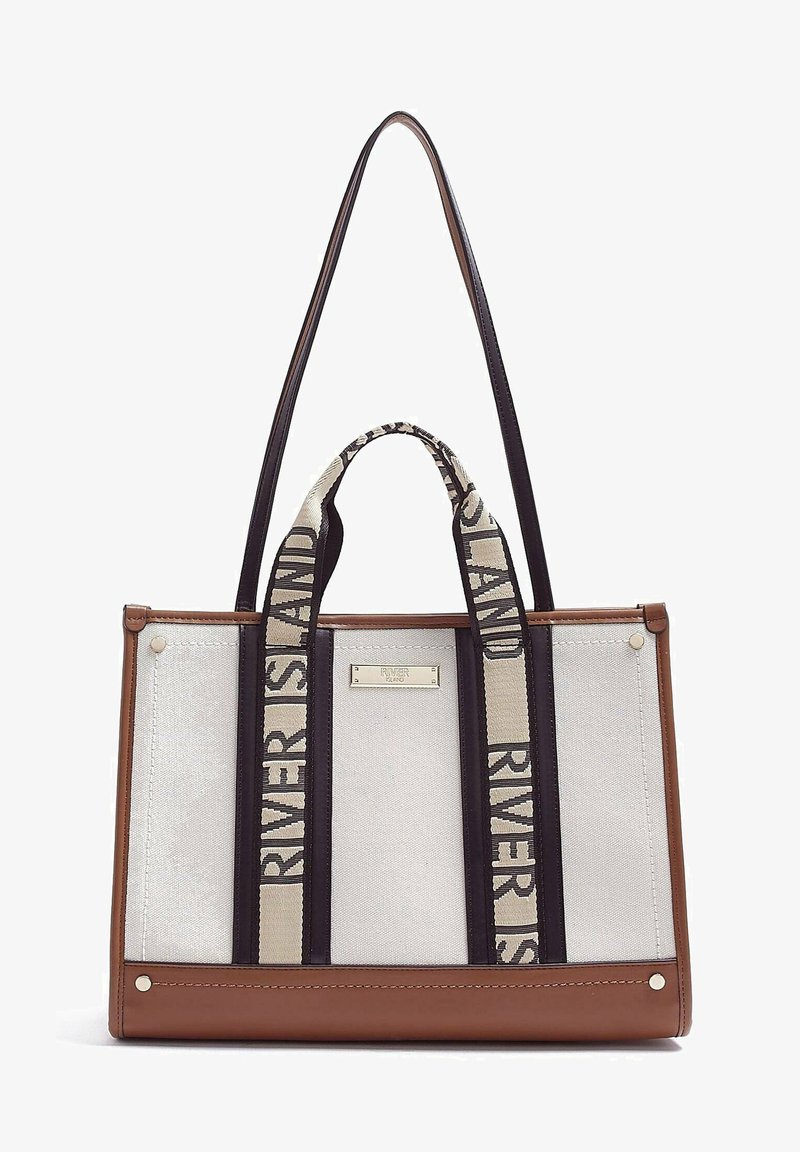 Brown and beige tote bag with canvas body, black straps, and logo-printed accents. Features metal hardware and a structured shape.