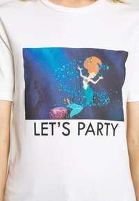 Bílé tričko se barevným grafickým motivem mořské panny s oranžovými vlasy na modrém pozadí, s textem "Pojďme slavit" v tučném černém písmu.