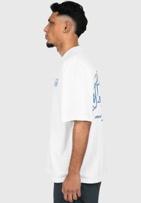 White short-sleeve t-shirt featuring blue graphics on the chest and back. Made of soft fabric with a relaxed fit and crew neck design.