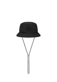 Svart bucket-hatt i tyg, med en strukturerad solstråledesign i mitten, samt hakrem och justerbar snodd.