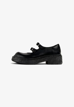 Schwarze Leder-Mary-Jane-Schuhe mit zwei metallischen Schnallenriemen, abgerundeter Zehenpartie und dicker, strukturiertem schwarzem Gummisohle.