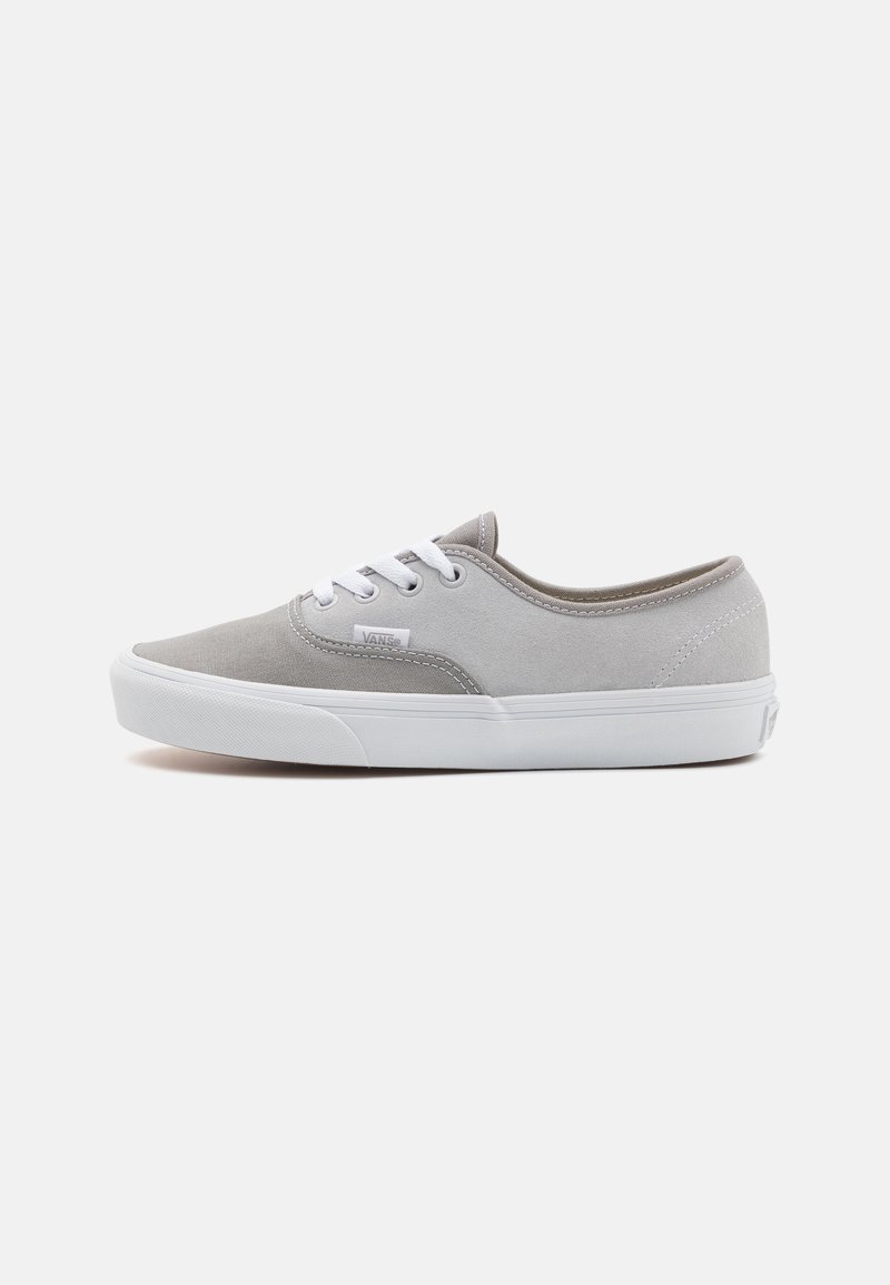 Gray canvas sneaker with white rubber sole, round toe, and white laces. Features a Vans logo on the side and beige accents on the rim.