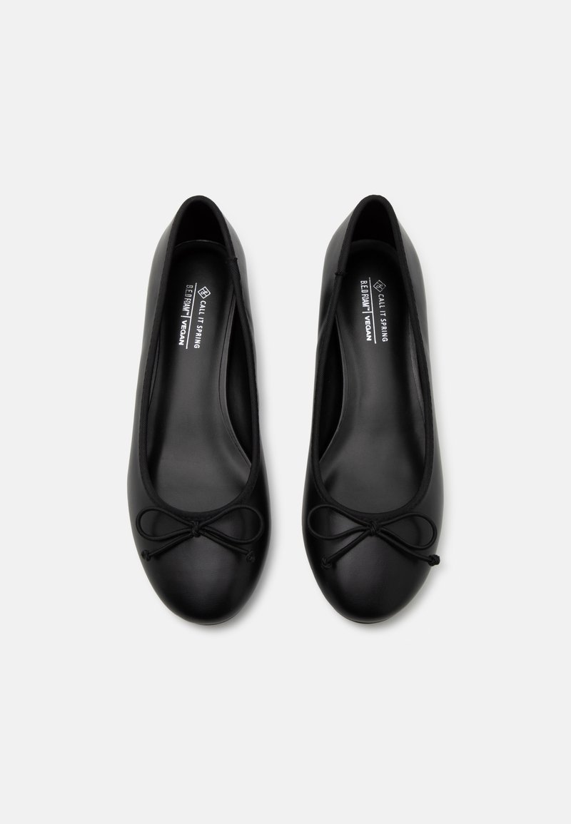 Ballerines noires végétaliennes avec un embout rond, accent en nœud à l'avant et texture lisse. L'intérieur présente des détails de la marque.