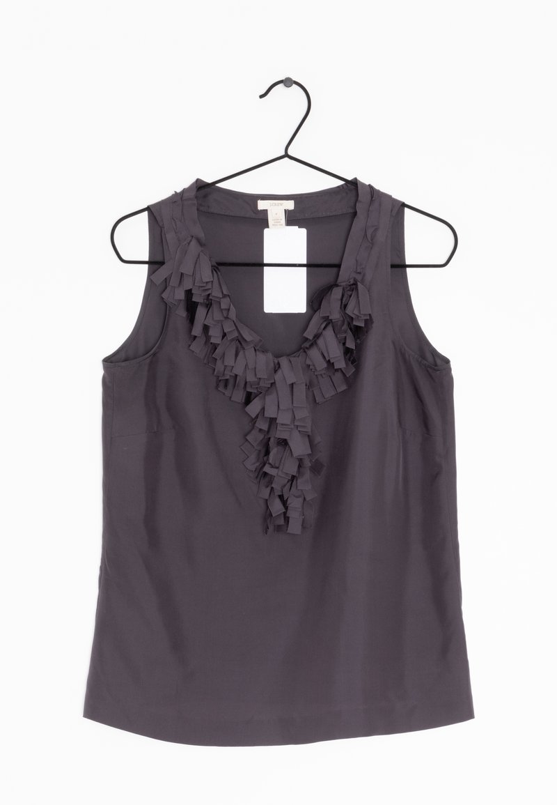 Blouse sans manches gris foncé avec un détail volanté au niveau de l'encolure en V, suspendue sur un cintre noir sur fond blanc.