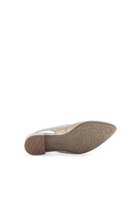 Chaussure à bout pointu en or métallique avec une tige en cuir lisse et un petit talon épais. La semelle présente un motif texturé et une marque.