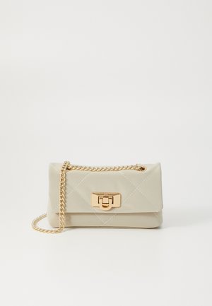 Sac à main beige matelassé avec une bandoulière en chaîne dorée, présentant un fermoir rectangulaire et des coutures blanches décorant la surface.