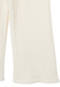 Pantaloni in maglia color crema con un motivo a treccia testurizzato, materiale morbido e vestibilità rilassata con orli alla caviglia.