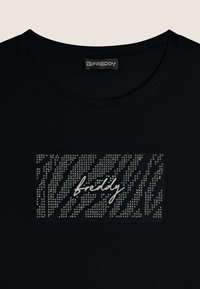 Camiseta negra con un diseño rectangular adornado con tachuelas plateadas en un patrón de rayas y la palabra "freddy" escrita en una tipografía blanca.