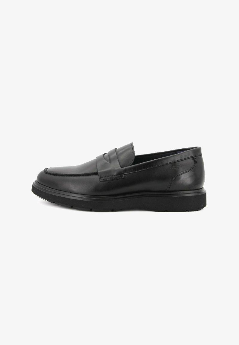 Mocassini neri in pelle con dettaglio cucito sulla tomaia e suola in gomma testurizzata, caratterizzati da un design elegante e slanciato.