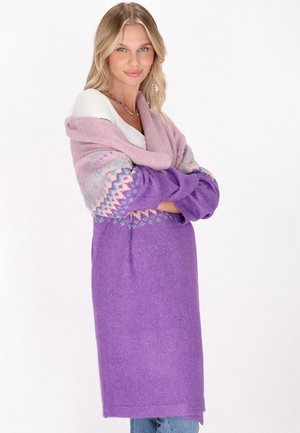 Cárdigan de punto morado con una manga en ombré rosa que presenta un patrón geométrico. Tejido suave y texturizado con un corte largo y relajado.