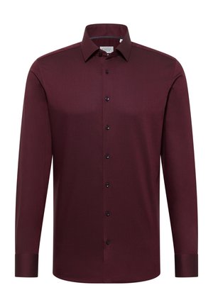 Chemise bordeaux à manches longues avec une finition texturée, des boutons noirs et un col classique. Coupe ajustée avec poignets boutonnés et matière lisse.