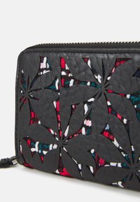 Portafoglio in pelle nera con intricati motivi a foglia intagliati, che rivelano un interno in tessuto intrecciato colorato con accenti rossi, bianchi e turchesi.