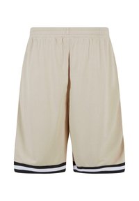 Shorts en mesh beige avec une texture respirante, dotés d'une ceinture élastique et de bandes noires à l'ourlet.