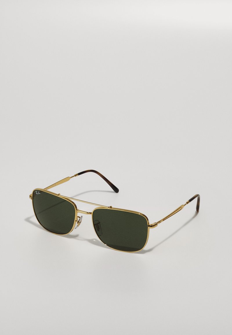 Ochelari de soare din metal cu tonuri de aur, cu lentile verzi. Formă rectangulară, cadru subțire și brațe cu accente maronii. Design simplu, fără ornamente.