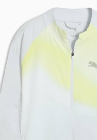 Witte en lichtgele lange mouwen jas met een ritssluiting aan de voorkant en een klein Puma-logo op de borst.