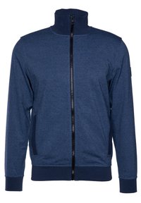 Giacca blu navy con zip alta, cerniera nera, polsini a costine e tasche laterali. Realizzata in un tessuto testurizzato e elastico.
