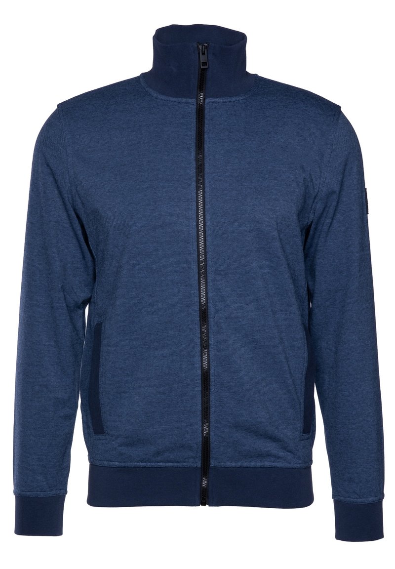 Giacca blu navy con zip alta, cerniera nera, polsini a costine e tasche laterali. Realizzata in un tessuto testurizzato e elastico.