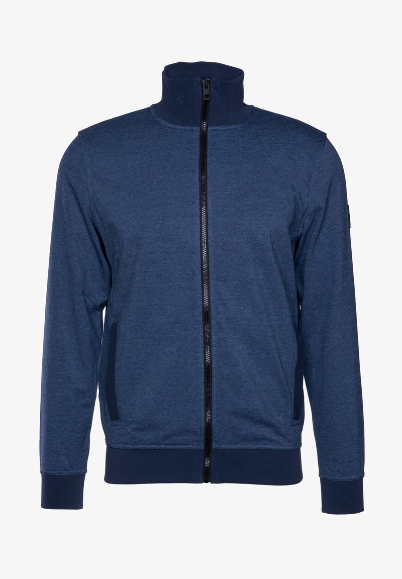 Giacca blu navy con zip alta, cerniera nera, polsini a costine e tasche laterali. Realizzata in un tessuto testurizzato e elastico.