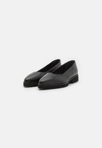 Ballerine nere in pelle con punta affusolata, caratterizzate da un design semplice e una suola in gomma nera testurizzata per una presa sicura. Nessuna ferramenta o decorazione visibile.
