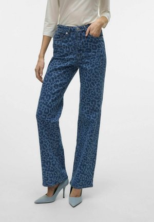 Blauwe luipaardprint jeans met een rechte pijp, voorzien van voorzakken en een knoopsluiting. Gecombineerd met lichtblauwe hoge hakken.