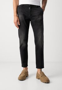 Pantaloni din denim negri cu o croială îngustă, ușor decolorati, design cu cinci buzunare și închidere cu un buton argintiu. Asortați cu mocasini bej.