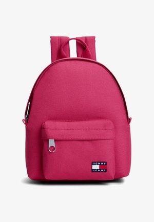Zaino rosa con tasca frontale con cerniera e patch con logo Tommy Jeans nell'angolo in basso a destra, su sfondo bianco.