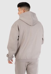 Lys grå hætte sweatshirt med en afslappet pasform, ribbede manchetter og nederste kant. Blød stofftexture, der har en stor hætte og sænkede skuldre.